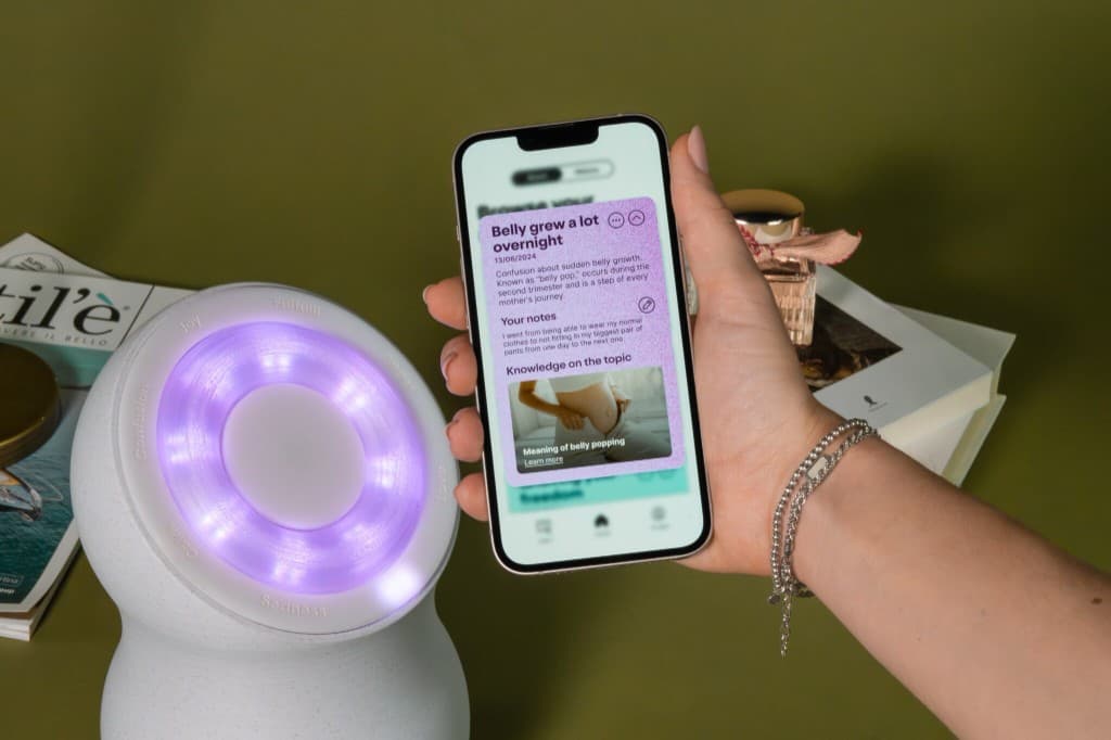 Mano che tiene smartphone con app accanto al dispositivo Loom