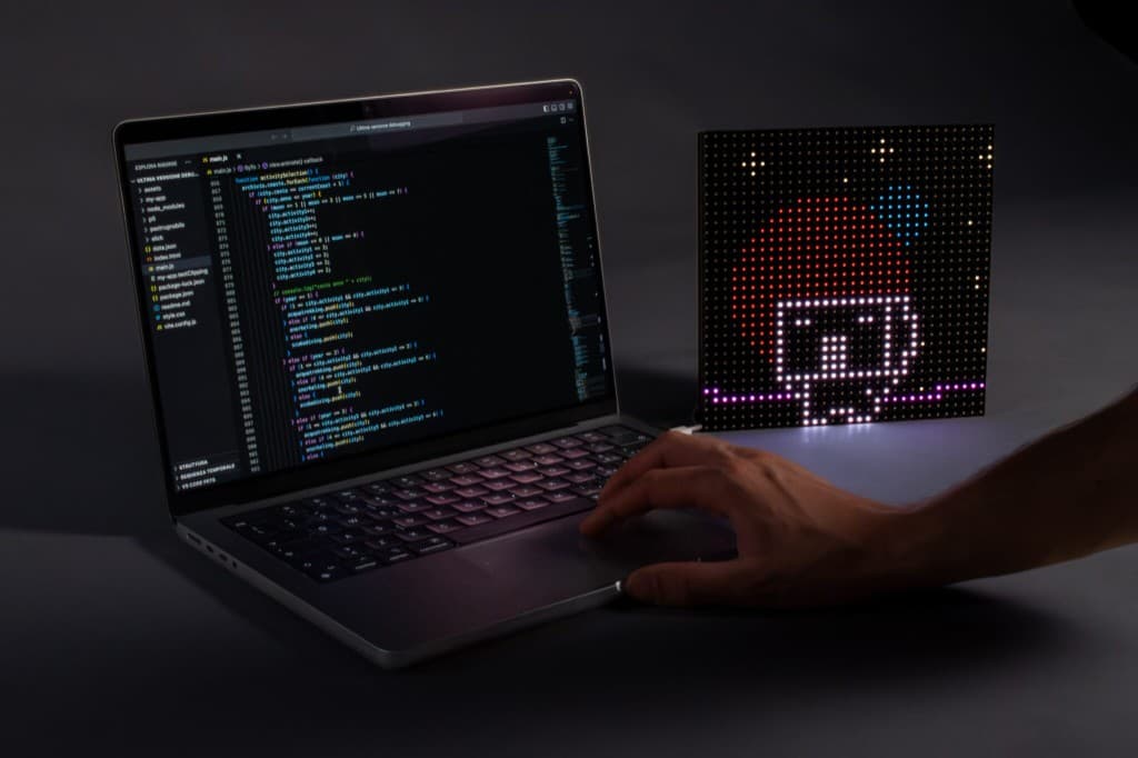 Mano sul trackpad del laptop accanto alla matrice LED accesa
