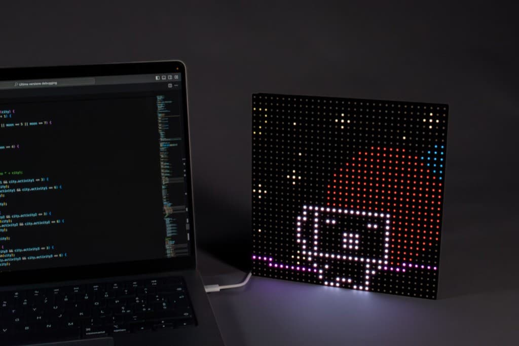 Setup con matrice LED, cavo USB e laptop in ambiente scuro