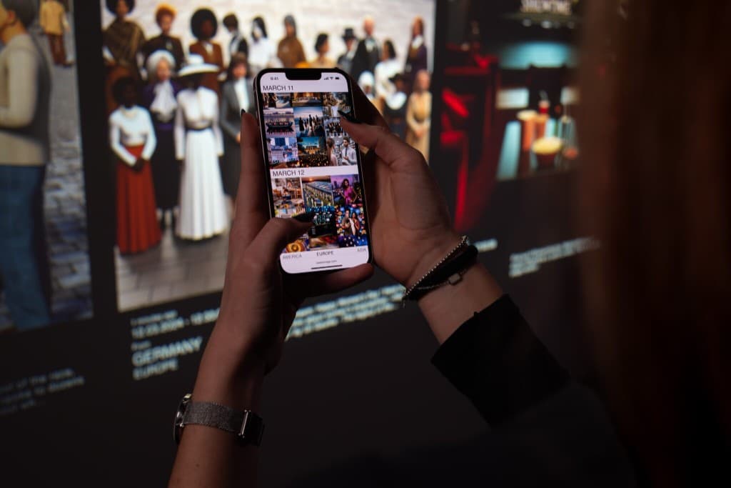 Persona che interagisce con l'installazione tramite smartphone