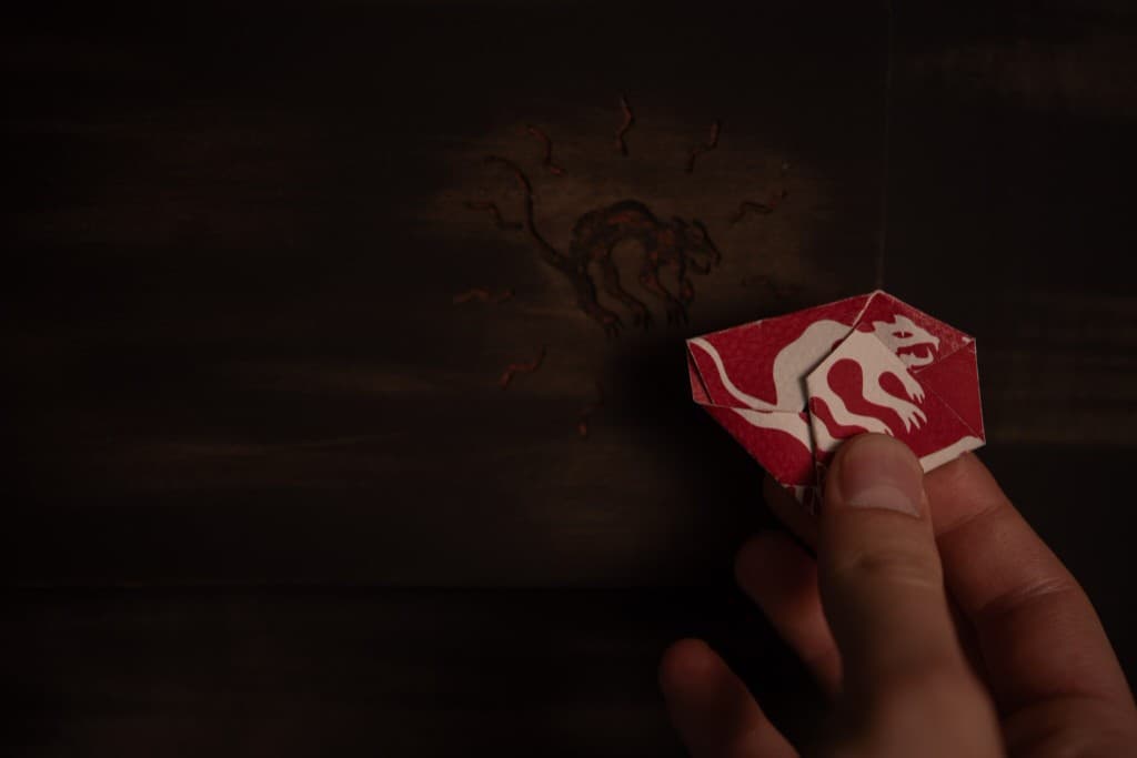 Mano con ticket rosso davanti alla porta del Nine Lives